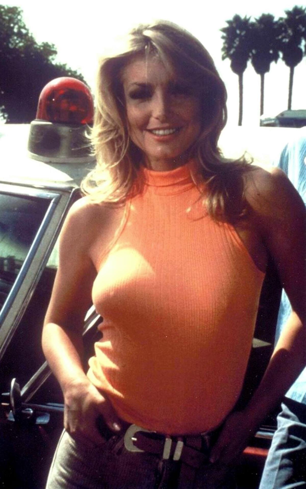 Heather Thomas vintage Hollywood candid photograph wearing an orange sleeveless top