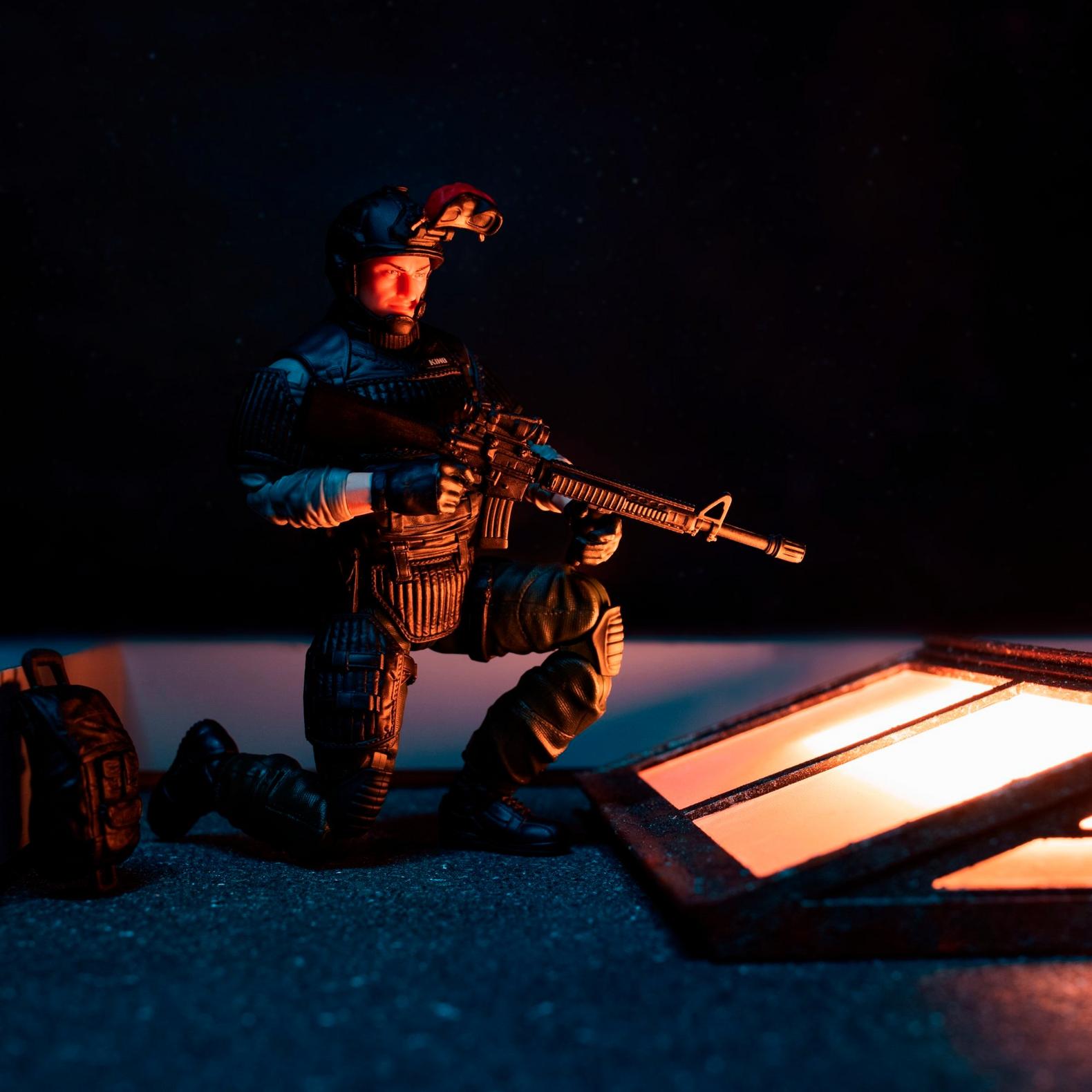 Night Force Sneak Peek kneeling with assault rifle on rooftop